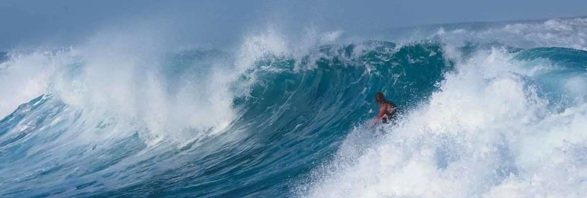 A surfer riding a large wave.