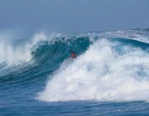 A surfer riding a large wave.