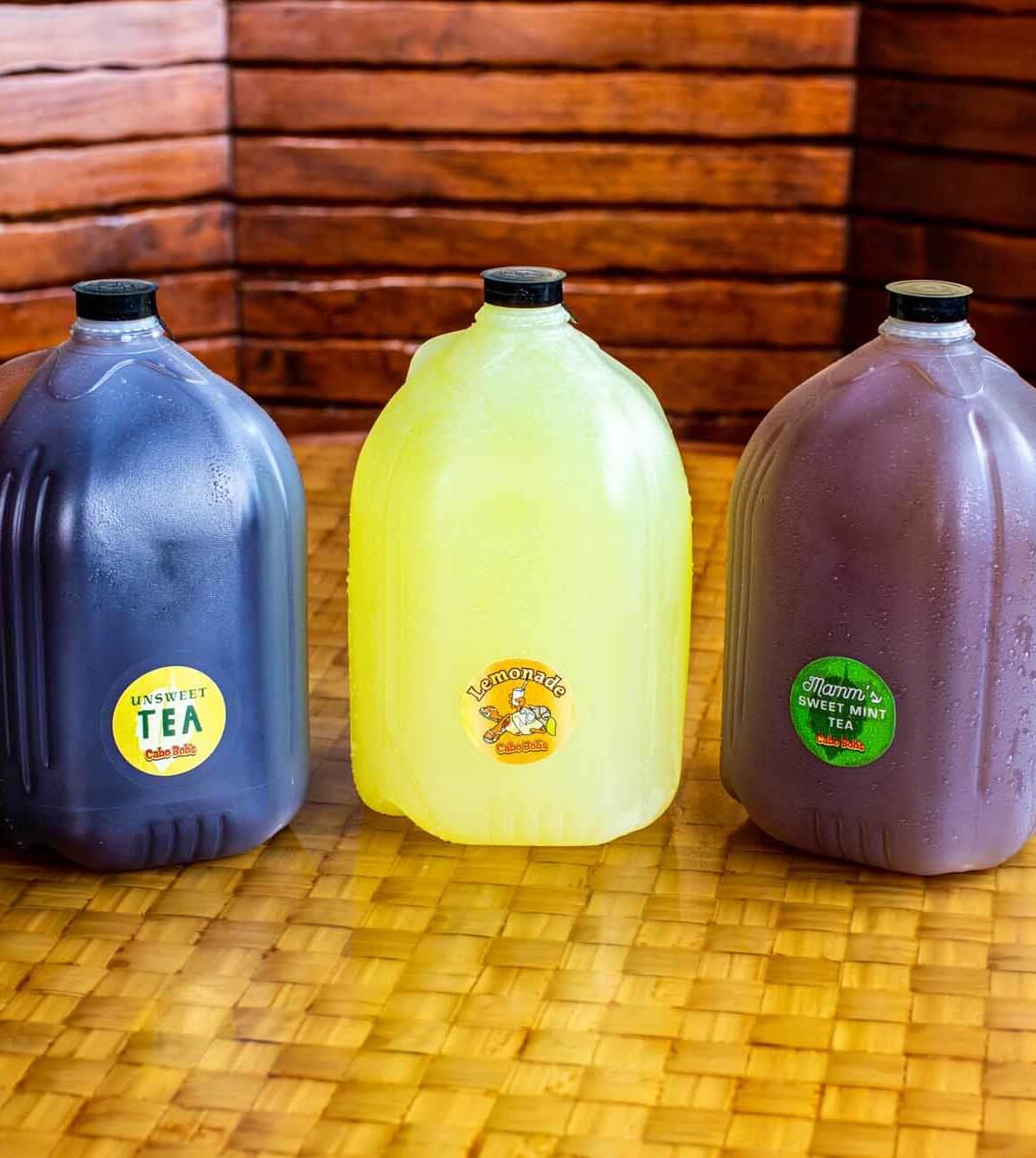 Three gallon jugs. One has a blue liquid in it, one purple, and one yellow.